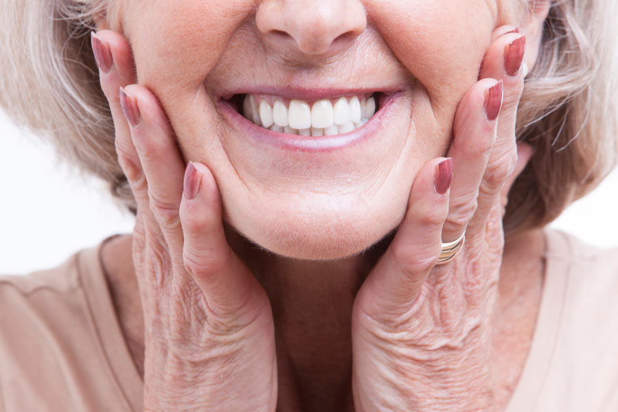 Smiling woman showing a closeup of dental veneers.