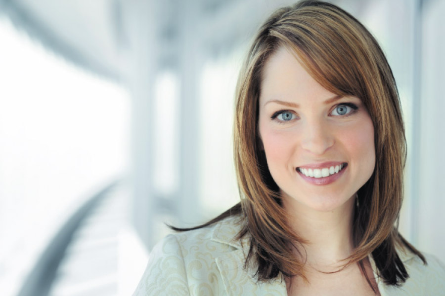 Attractive smiling young adult woman in business attire.