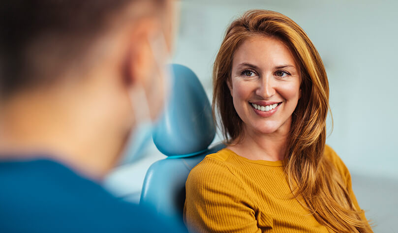 smiling woman talking with her dentist