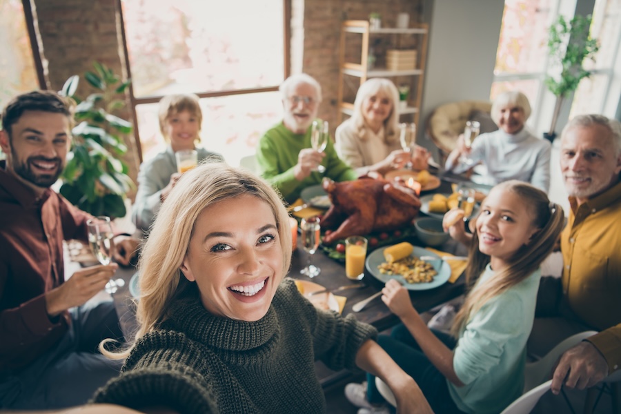 dental health during the holidays, family smiling around the thanksgiving table