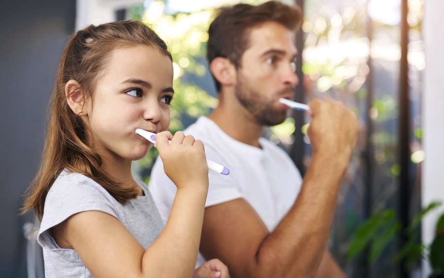 father and daughter brushing their teeth, healthy dental goals for a healthier smile in 2026