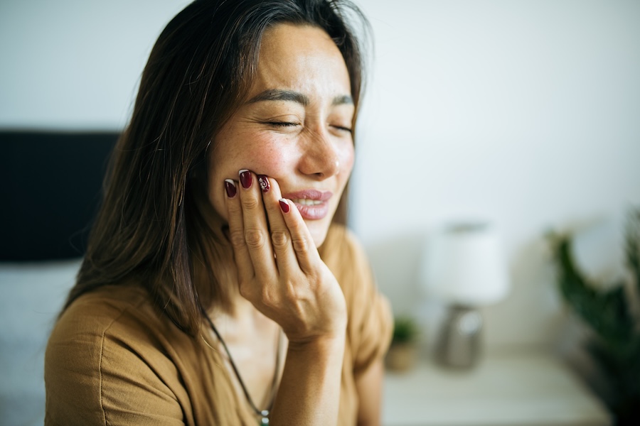 woman with toothache considered dental extraction or root canal therapy